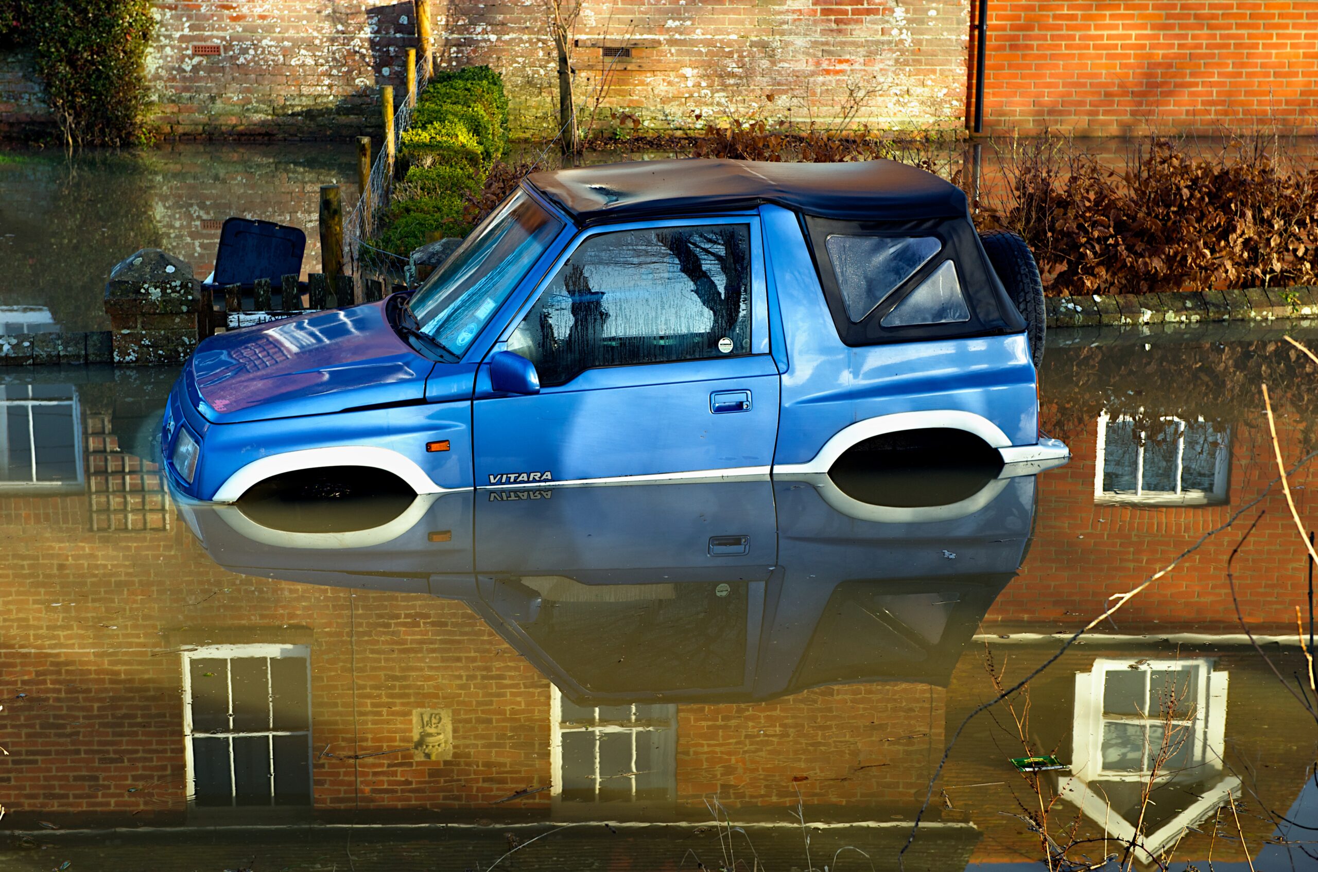 A car partially submerged in floodwater.