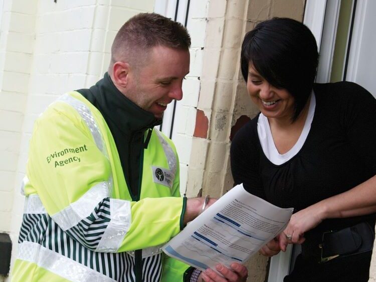 Environment Agency staff member discussing flood plans with a resident.