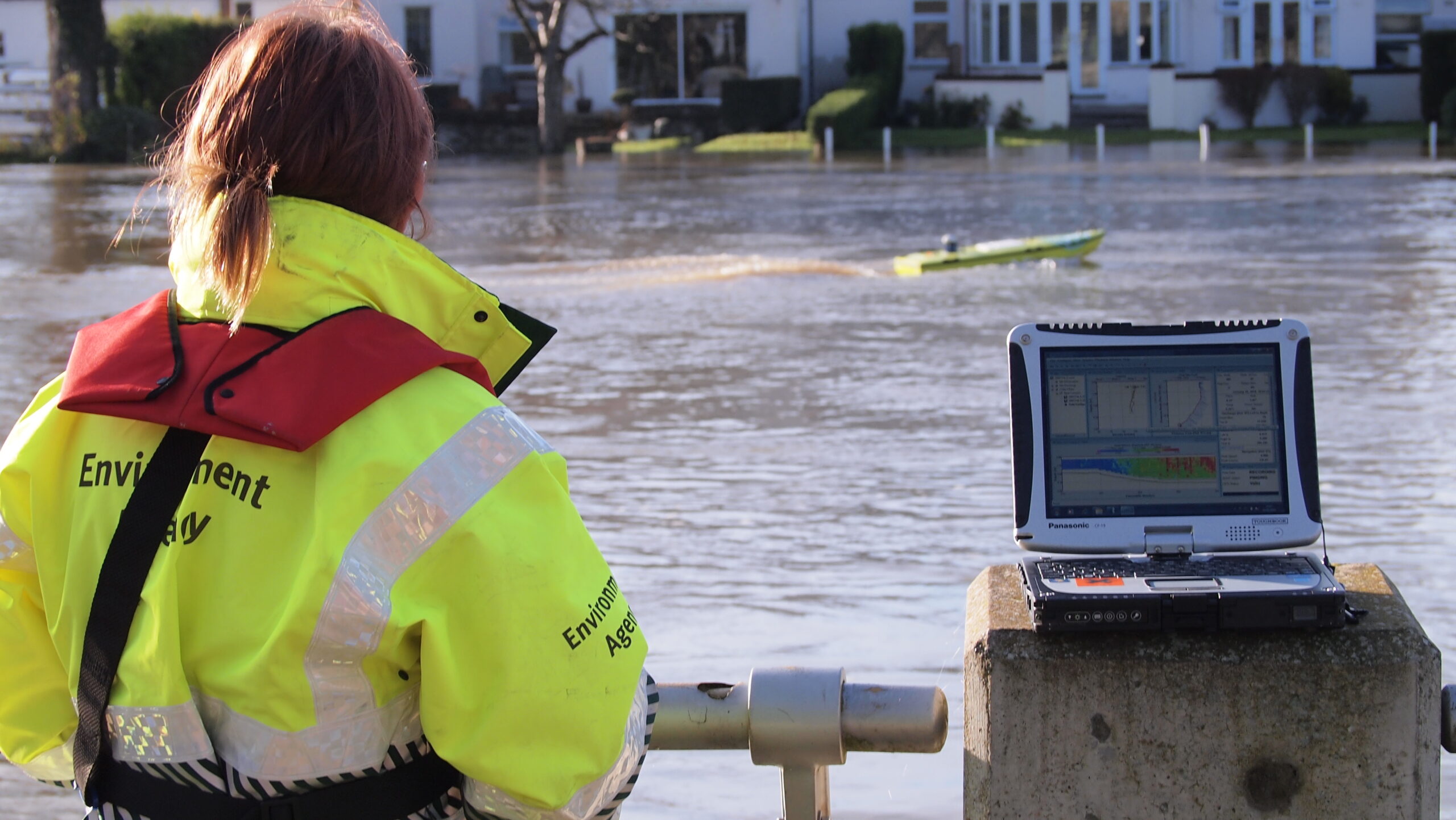An Environment Agency staff member undertaking a survey of floodwater using a remote controlled boat.