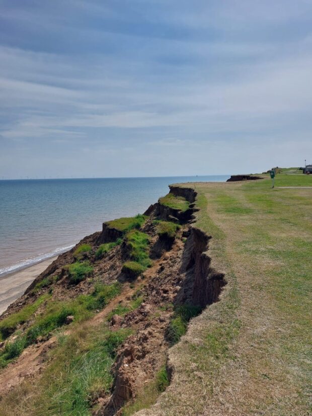 A cliffside next to the sea showing coastal erosion.