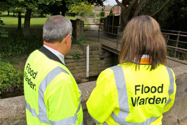 Two flood wardens checking a river level.