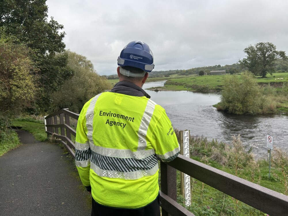 A member of Environment Agency staff overlooking a river